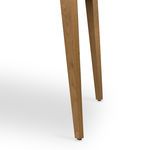 Lower section of tapered oak leg showing wood texture and floor protector on Armstrong Desk