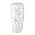 Alternate angle of tall porcelain vase with hand-formed flower decorations on smooth white surface