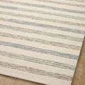 Close-up of soft multi-tone stripes and wool fiber texture on flat beige striped rug