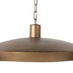 Close-up view of hammered brass cylindrical connector piece holding chain to pendant shade
