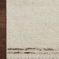 Corner view of Roman Ivory Granite Rug laying on dark wood floor highlighting edge stitching and weave texture