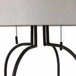 Detail of two pull chains hanging from black metal frame under the lamp shade