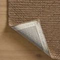 Corner of Kai Pebble Rug lifted to reveal backing with branded weave and sewn edge