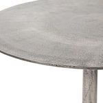 Close-up of the edge of the tabletop highlighting the metal's textured finish and edge detail