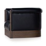 Deep side angle showing curved backrest and seamless leather wrapping around the frame