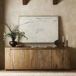 Painting mounted above rustic wood cabinet with decorative vases and black candles in warm-toned room