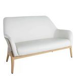 Compact natural wicker loveseat with light wood frame and plush white vinyl cushions, rounded back and arms