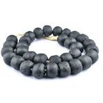 Coiled strands showing bead size diversity and matte finish with visible natural fiber cord