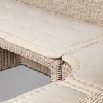 Close detail of rattan base supporting cushioned seating with woven pattern visible