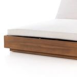 Lower angle of the chaise's base corner emphasizing the teak frame's sharp edge