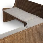 Close-up angled view of tufted beige fabric cushions on rattan bench corner section