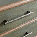 Close-up of textured metal bar pull and wood grain detail on the seagrass green drawer front of the Retreat Pole Rattan ch...