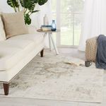 Styled room setting with rug under sofa and side table beside bright window