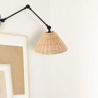 Wall sconce installed on white wall above framed art, showing scale and styling in room context