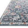 Close-up angled view of rug showing low pile texture and color blending of blue, rust, and ivory