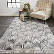 Beckett chevron rug styled in living room with beige armchair and dark wood flooring