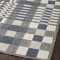 Close-up of rug surface emphasizing pattern variation and dense weave on wood floor