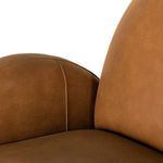 Zoomed view of inner armrest stitching and leather texture on cognac chair