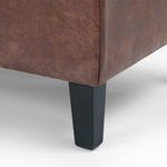Close-up of black tapered leg and tufted vintage tobacco faux leather corner