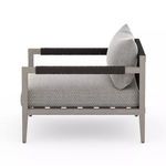 Side profile displaying sleek armrests wrapped in black material and deep cushioned seat