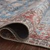 Rolled up Loren Blue / Brick Rug showcasing backing and plush blue and red patterned surface