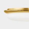 Close-up side angle highlighting aged brass mount perforations and curved edge detail