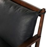 Detailed view of black leather cushion corner tied around wood frame