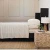 Remi Natural Bamboo Linen Sheet Set in warm natural hue on black bed frame with textured side table and lamp