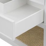 Open drawer showing white interior and drawer front detail above woven lower shelf on Sienna table base