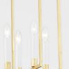 Detailed close-up of four lit candle-style bulbs with gold accents inside pendant frames