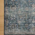 Partial top-down view of rug corner on hardwood floor highlighting border detail