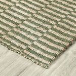 angled close-up of rug edge on light wood floor highlighting woven texture and pattern continuity