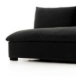 Side angle focused on sofa’s thick arm-less frame, cushion, and block leg base