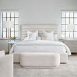 Bedroom setting with cushioned bench added at foot of the bed and textured area rug underneath