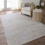 Dounia rug styled in living room scene under chair and side table, showing scale and color harmony.
