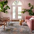 Giada Rug shown in living room with pink sofa, golden face side table, and green plants