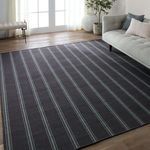 Low angle showing rug in a modern living room beside a grey upholstered sofa