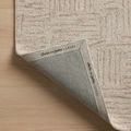 Corner of Polly Smoke Sand Rug flipped to show branded fabric backing with Chris Loves Julia x Loloi label