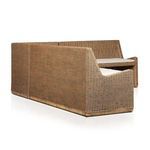 Cushioned seating area highlighting tufted detailing on beige fabric above natural woven rattan