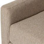 Close-up of armrest and seat cushion edge showing fabric weave pattern and stitching detail