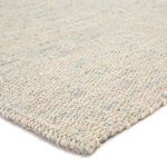 Close-up of woven jute fibers showing thick braided texture with ivory and blue tones