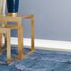 Lower angle shows Plano Side Tables nested on blue rug beside sofa with blue lamp on top