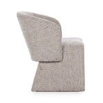 Side profile highlighting chair’s thick cushioned backrest and sloped base in beige upholstery