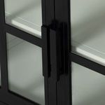 Corner close-up highlighting the media console’s smooth black top panel and metal frame