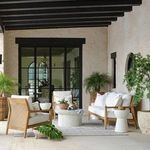 Outdoor lounge space featuring Savannah Teak Sofa with soft cushions, woven accents, and natural decor