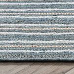 Close-up of Del Mar rug edge highlighting woven jute and cotton textures in blue, beige, and ivory stripes