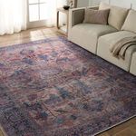 Rug placed in a living room setting beside beige sofa showing scale and room styling with natural light