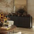 Dining area close-up with the painting on the sideboard and floral arrangement foreground.