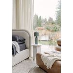 Echo Lamp on a small round white marble side table next to a beige fabric sofa near window
