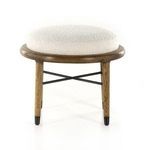 Front view with bright lighting emphasizing the ottoman’s circular top and iron stretcher